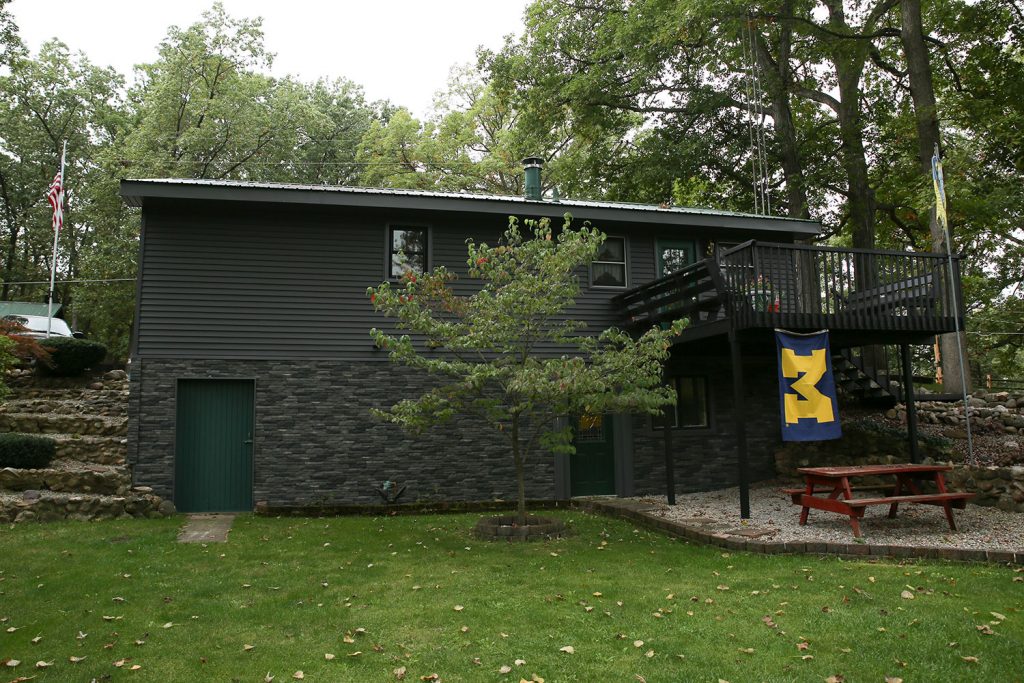 Stacked stone and dark siding on lake home.