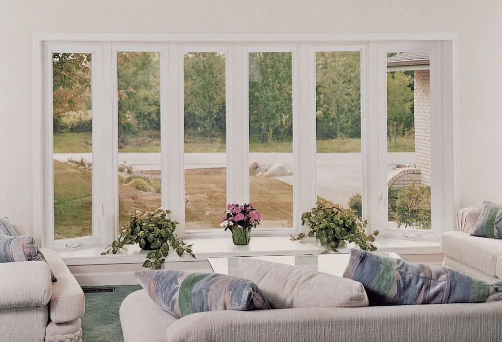Large white bow window looking out from a living room.