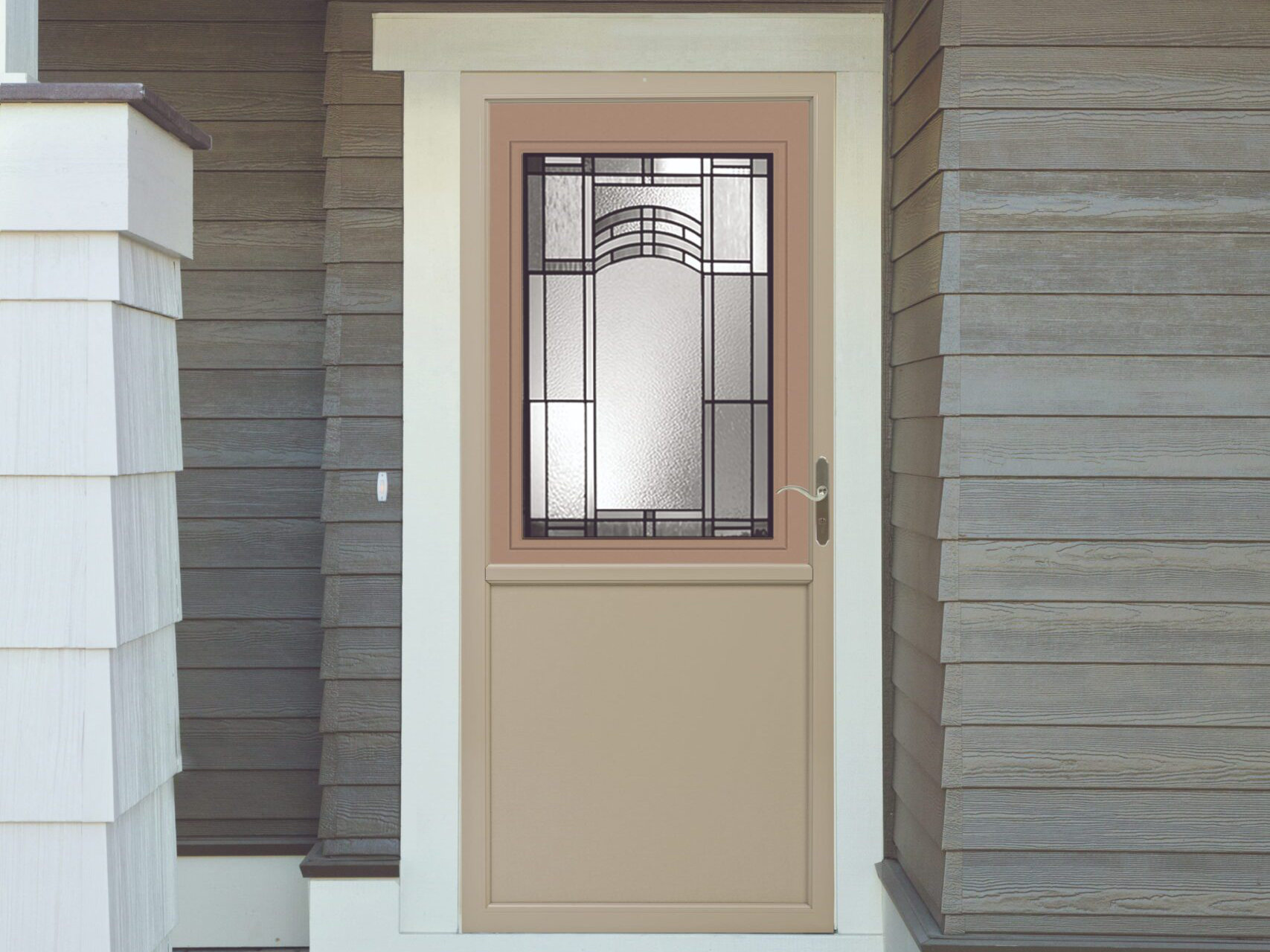 Decorative storm door installed on a wood sided home